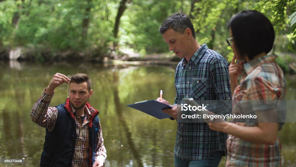 Trois scientifiques explorant l’eau dans le lac - Photo de Environnement libre de droits