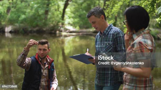 Three Scientists Exploring Water In Lake Stock Photo - Download Image Now - Environment, Water, Research