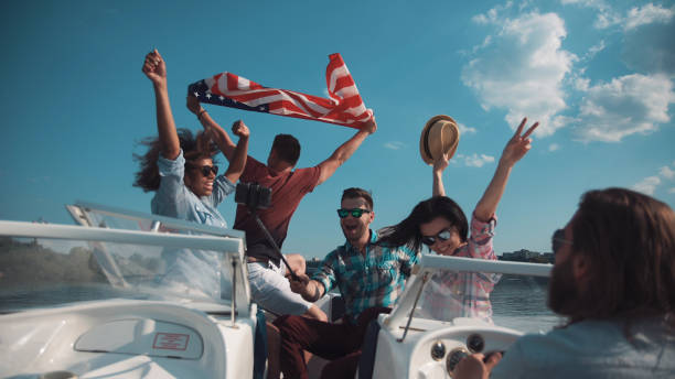 Friends having fun on boat Group of laughing friends having fun on boat and taking selfie. yacht selfie stock pictures, royalty-free photos & images
