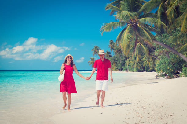 istock happy loving couple walk on beach 696278102