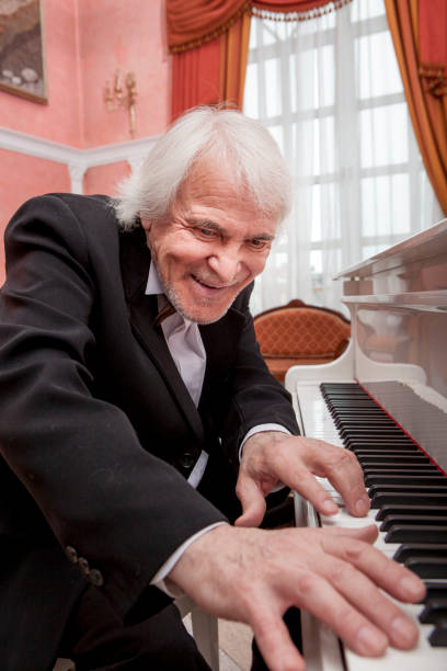 istock Mature musician playing a white piano 696281538