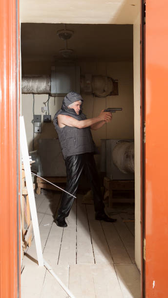istock Bandit armed with a gun in the attic 696281650