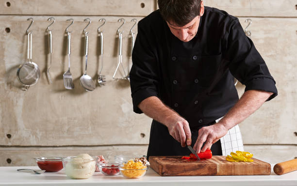 istock Restuarant hotel private chef cutting red pepper on board 696289414