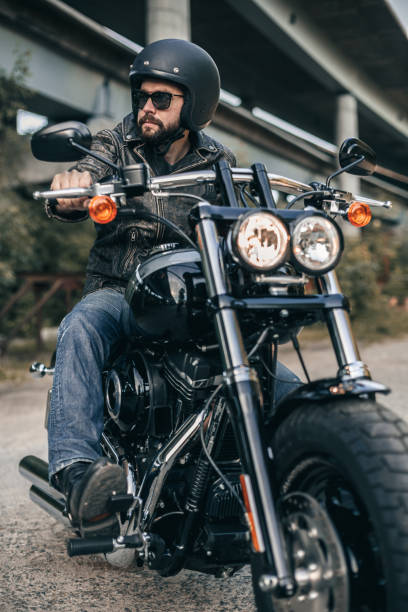 istock Biker in helmet and leather jacket sitting on a motorcycle 696289840