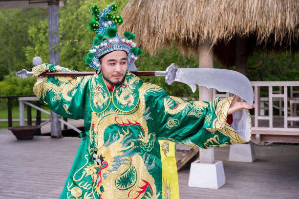 hombre chino en traje típico con la espada al aire libre - 20s standing one man only sword fotografías e imágenes de stock