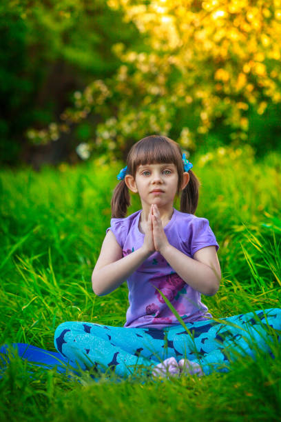 istock beautiful girl doing yoga outdoors On green grass 696297002
