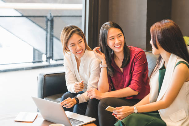 tres hermosas chicas asiáticas charlando juntos en sofá café o cafetería. habla de chismes, estilo de vida casual con tecnología gadget, inicio del sme, estudiantes universitarios o concepto de mujer de negocio trabajo - asiático de asia sudoriental fotografías e imágenes de stock