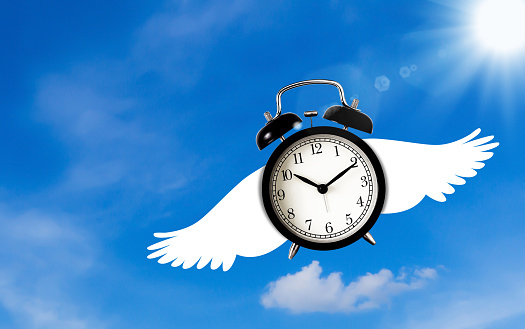 Time management concept, business planning, flying alarm clock on blue sky background
