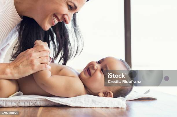 Mother Changing Diaper To Toddler Stock Photo - Download Image Now - Baby - Human Age, Mother, Latin American and Hispanic Ethnicity