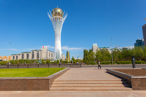 Astana, Kazakhstan - May 21, 2017: Photograph in the capital of Kazakhstan. Around the grass and trees. People are walking around the city, resting. In the background is the residence of President Nursultan Nazarbayev.