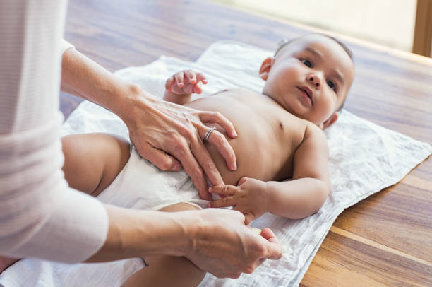 Mother changing baby diaper Mother hands changing baby nappy. Mother putting diaper on her hispanic son lying in nursery. Close up of mother giving baby diaper change at home. adult diaper stock pictures, royalty-free photos & images