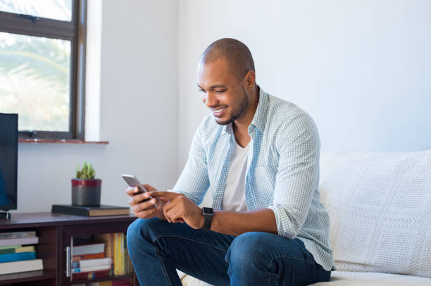 african man typing phone message - online messaging facebook touch screen e mail imagens e fotografias de stock