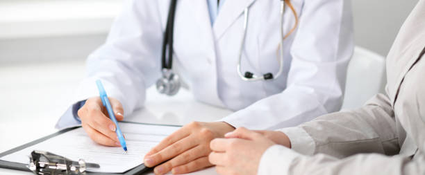 istock Doctor and  patient  sitting at the desk 696314194