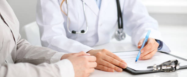 istock Doctor and  patient  sitting at the desk 696314238