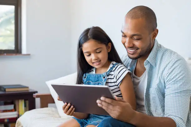 Photo of Father and daughter using tablet