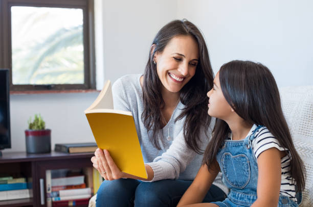 чтение матери ребенку - family reading book child стоковые фото и изображения