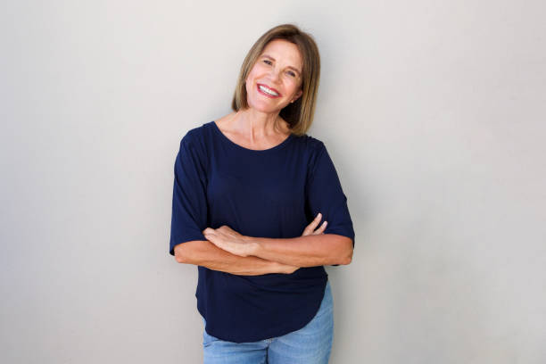 istock confident older woman smiling against gray background 696318320