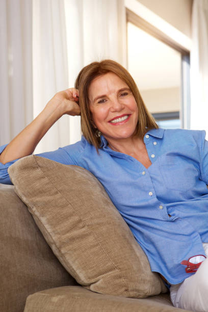istock older woman relaxing at home on sofa 696318336