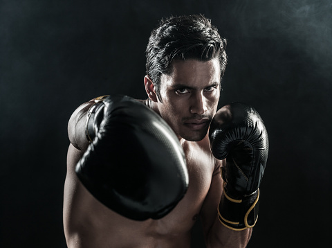 Hispanic Boxer In Dramatic Lighting and Smoke, punching.