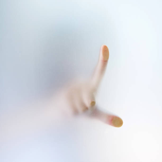 曇らされたガラスの背後にあるポインティング指の影 - trapped horror fog human hand ストックフォトと画像