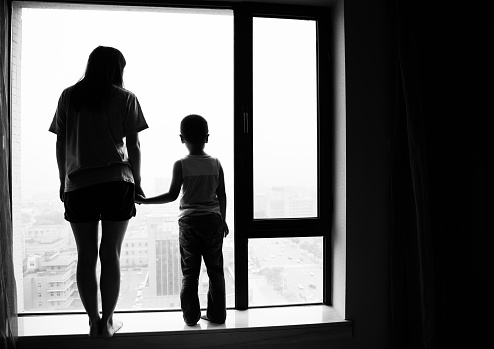 Pensive mother and son looking out of window
