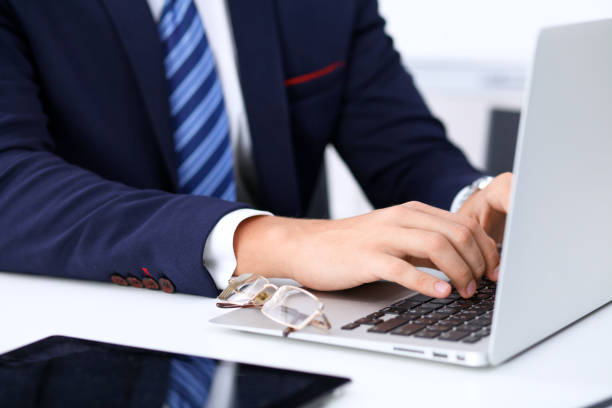 istock Young man working with laptop computer, man's hands on notebook, business person at workplace 696350680