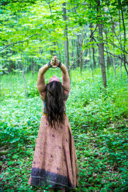 istock Mature woman practicing yoga outside in the forest 696353320
