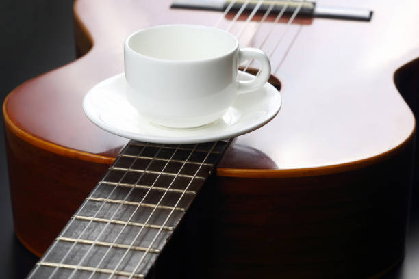 istock empty white cup lying on the acoustic guitar 696354648