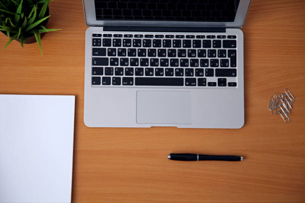 istock Office table with laptop, notepad and coffee cup. View from above with copy space 696371114