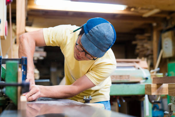 istock Craftsman cutting wood in her workshop 696371126