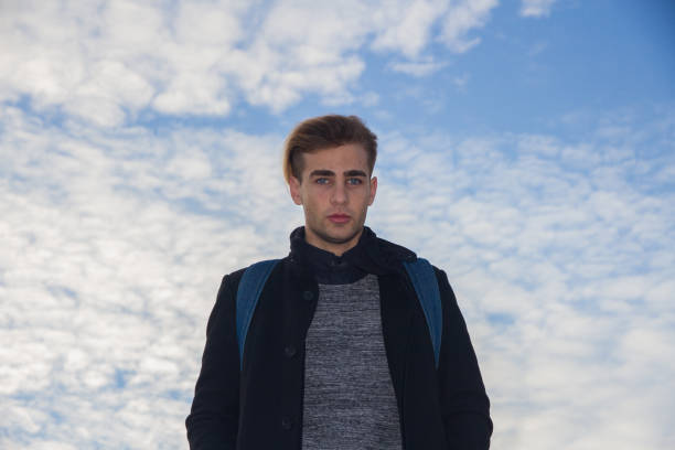istock Man with blue eyes on a background of blue sky. 696373082