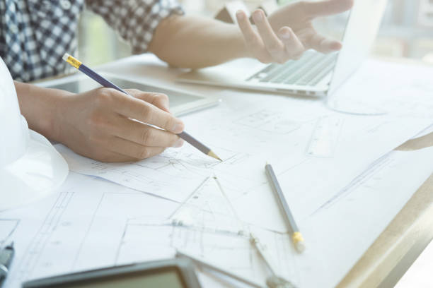 istock Architect working on real estate project at workplace. Male engineer hand working with living house blueprint at office. Business, people, construction and building concept 696373990