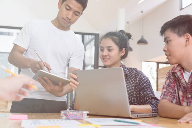 istock startup young successful team on meeting in modern office interior brainstorming, make a business plan, working on laptop computer and tablet with  financial and marketing graph and chart 696374198