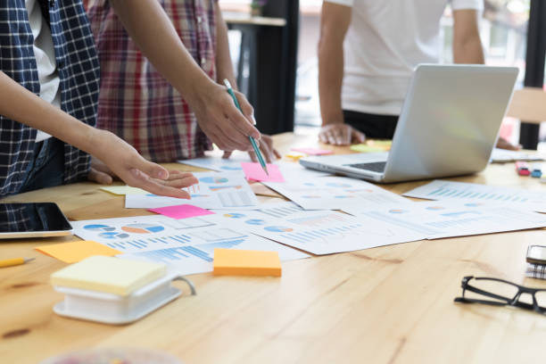 istock startup young successful team on meeting in modern office interior brainstorming, make a business plan, working on laptop computer with financial and marketing graph and chart 696374228