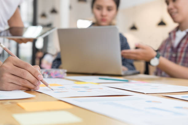 istock startup young successful team on meeting in modern office interior brainstorming, make a business plan, working on laptop computer and tablet with  financial and marketing graph and chart 696374274