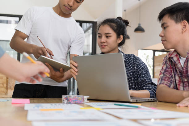 istock startup young successful team on meeting in modern office interior brainstorming, make a business plan, working on laptop computer and tablet with  financial and marketing graph and chart 696374278