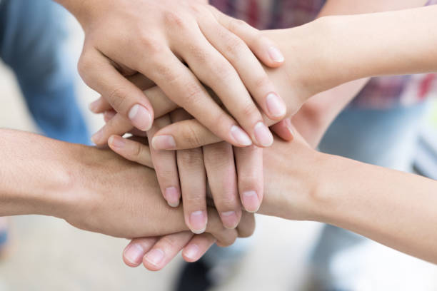 istock young college student joining hand, business team touching hands together - unity, harmony, teamwork, friends concept 696374286