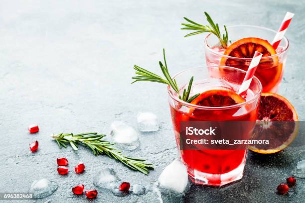 Red Cocktail With Blood Orange And Pomegranate Refreshing Summer Drink On Gray Stone Or Concrete Background Holiday Aperitif For Christmas Party Stock Photo - Download Image Now