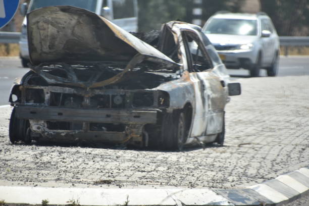 istock burnt car on the road 696387608