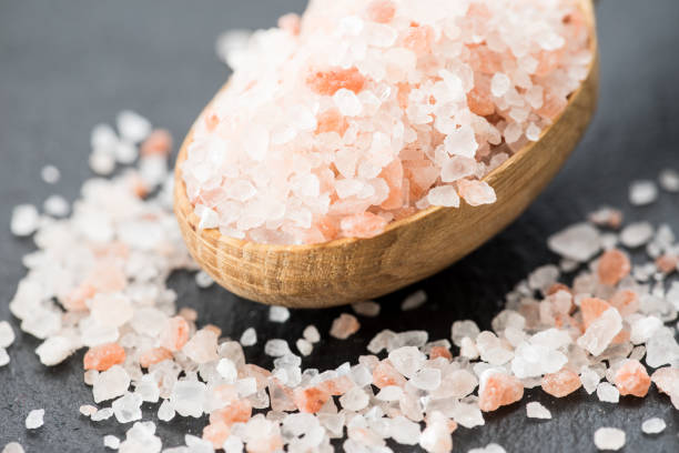 himalayan pink crystal salt. spoon of pink himalayan salt on slate plate - salt crystal spoon food imagens e fotografias de stock