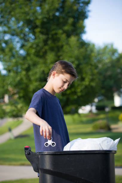istock Teen Boy Putting Fidget Spinner in Trash 696395712