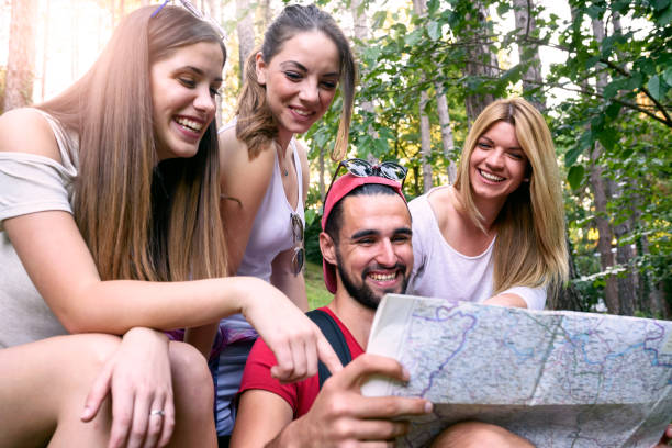 istock Group of friends looking map outdoors 696417532