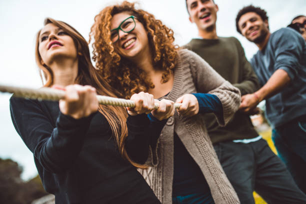 amigos disfruten el juego de tira y afloja - lucha de la cuerda fotografías e imágenes de stock