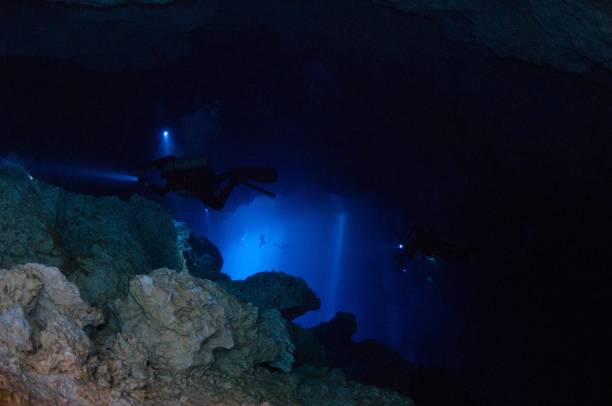istock view of divers in light behind rocks 1 696426818