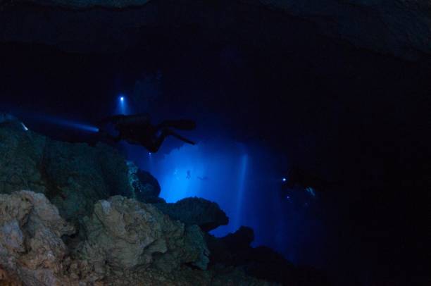 istock view of divers in light behind rocks 2 696426844