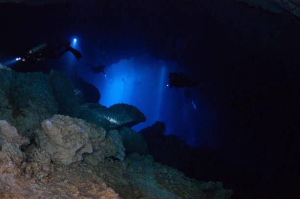 istock view of divers in light behind rocks 3 696426858