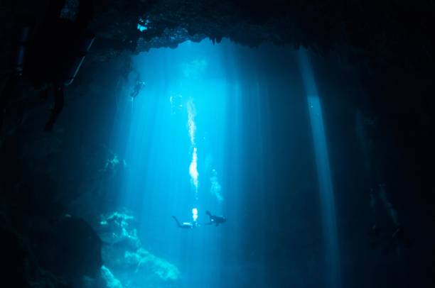istock view of large pit cavern cenotes divers and bubbles in bright blue laser lights 4 696427196