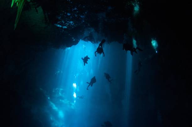 istock view of large pit cavern cenotes divers and bubbles in bright blue laser lights 3 696427208