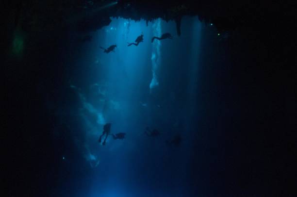 istock view of large pit cavern cenotes divers and bubbles in bright blue laser lights 1 696427214