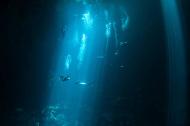 istock view of large pit cavern cenotes divers and bubbles in bright blue laser lights 6 696427246